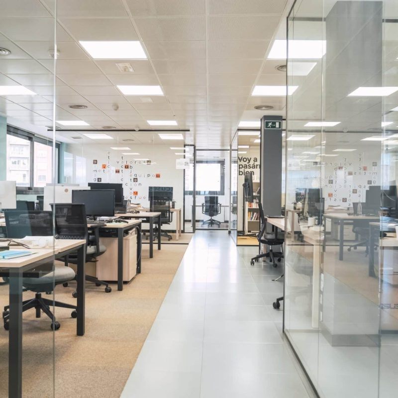 Interior of spacious and organized creative coworking workspace with arranged computer desks and chairs in cabins